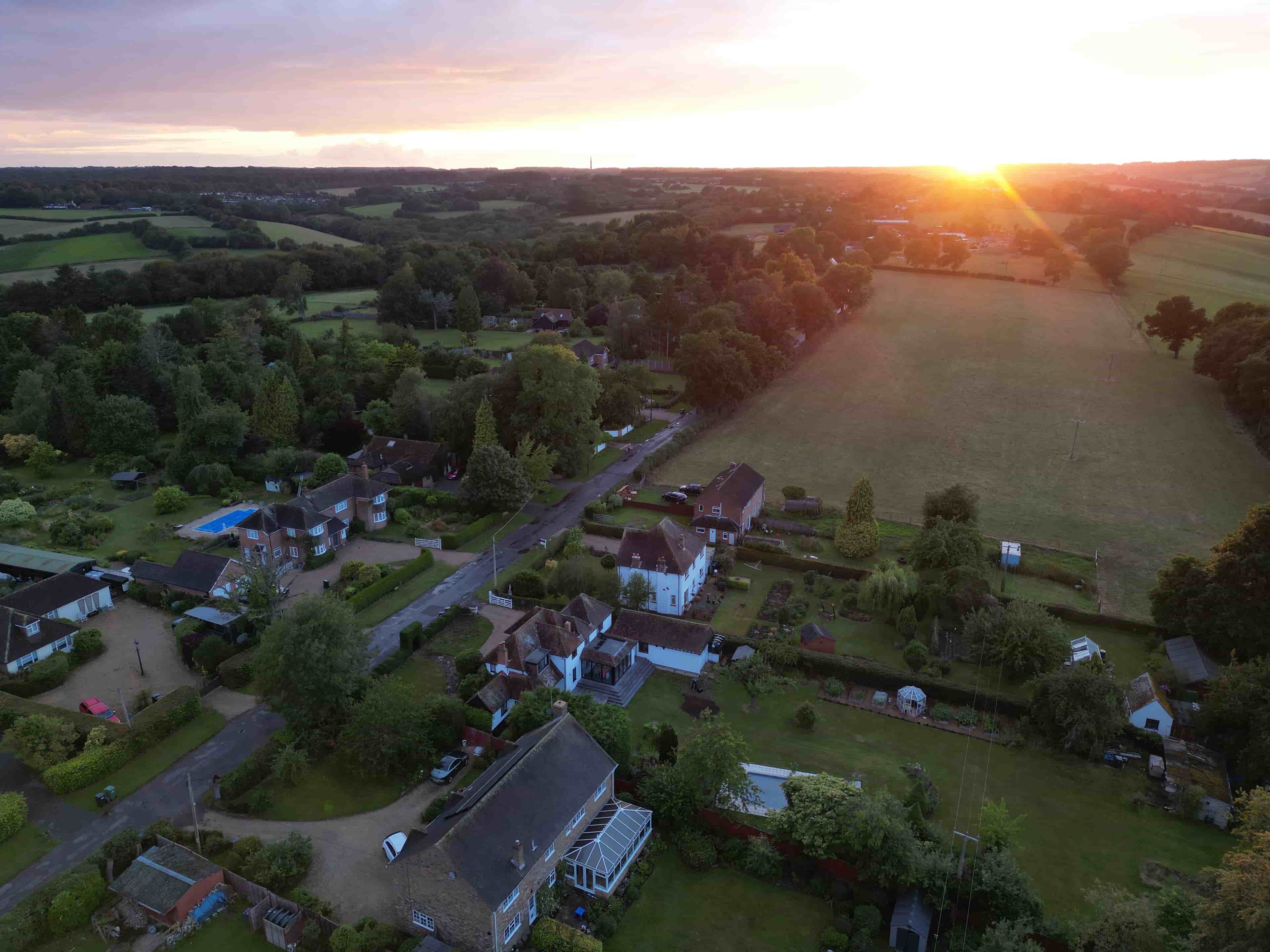 A Sunset picture topdown bird's-eye view of a gorgeous properties in a Radnage village